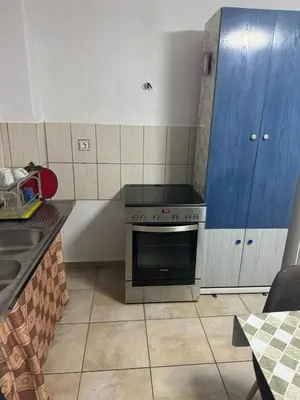 a kitchen with a stove and a blue cabinet at DianaHub in Artemida