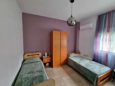 a room with two beds and a cabinet and a window at DianaHub in Artemida