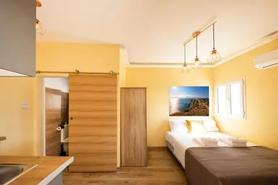 a bedroom with a bed and a sink in a room at Island In The Sky, Acropolis and City Views! in Athens