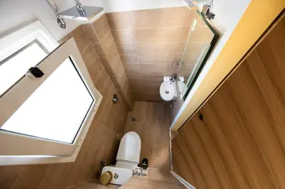 a bathroom with a toilet in the middle of a room at Island In The Sky, Acropolis and City Views! in Athens