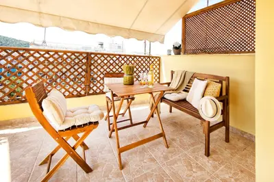 a porch with a wooden table and chairs at Island In The Sky, Acropolis and City Views! in Athens