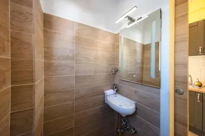 a bathroom with a sink and a mirror at Island In The Sky, Acropolis and City Views! in Athens