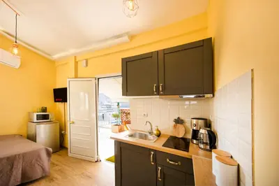 a small kitchen with black cabinets and a sink at Island In The Sky, Acropolis and City Views! in Athens