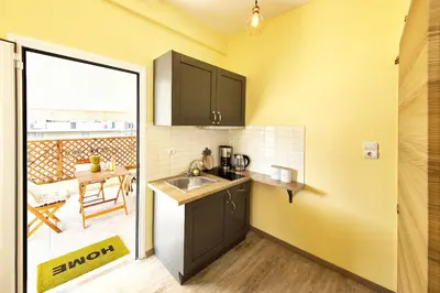 a small kitchen with a sink and a table at Island In The Sky, Acropolis and City Views! in Athens