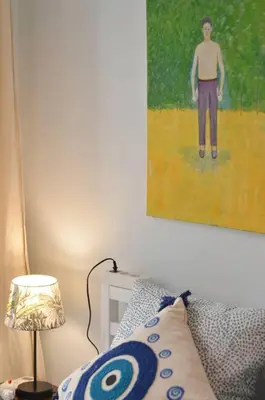 a bedroom with a painting of a boy on the wall at Piraeus Pasalimani LargeTerrace Seaview Apartment in Piraeus
