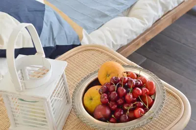 a basket of fruit on a table next to a bed at Piraeus Pasalimani LargeTerrace Seaview Apartment in Piraeus