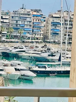 a group of boats docked in a harbor with buildings at Piraeus Pasalimani LargeTerrace Seaview Apartment in Piraeus