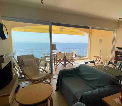a living room with a view of the ocean at Scenic View Apartment by Saronida Beach in Saronida