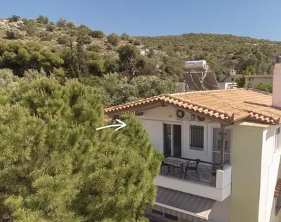 a white house with a balcony and trees at Combination of the sea and the countryside in Vari