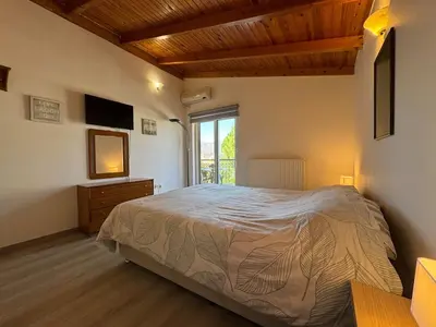 a bedroom with a large bed and a window at Combination of the sea and the countryside in Vari