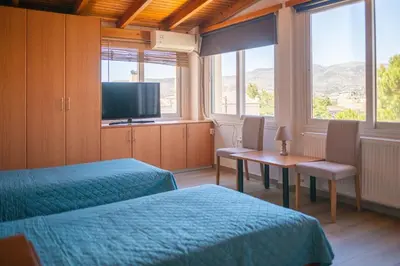 a hotel room with two beds and a television at Combination of the sea and the countryside in Vari