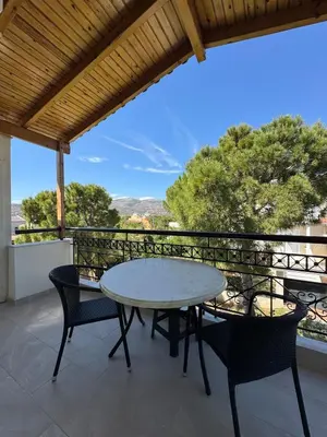 a patio with a table and chairs on a balcony at Combination of the sea and the countryside in Vari