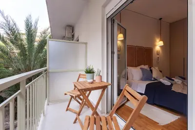 a balcony with a bed and a table and chairs at New Spacious 3BR Apt Near Kypseli 8 min to Metro in Athens