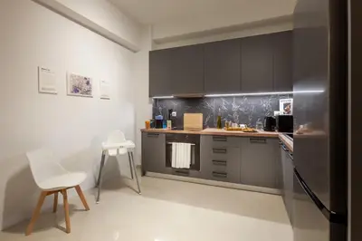 a kitchen with gray cabinets and a white counter top at New Spacious 3BR Apt Near Kypseli 8 min to Metro in Athens