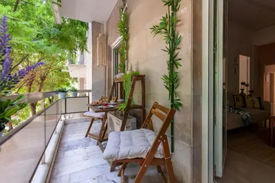 a balcony with chairs and plants on it at New Spacious 3BR Apt Near Kypseli 8 min to Metro in Athens