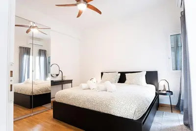 a bedroom with a bed and a ceiling fan at Athena's Escape-Your Greek base! in Athens