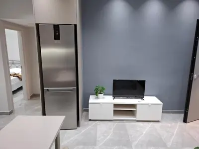 a kitchen with a refrigerator and a table with a laptop at Nikaia Luxury Dream in Piraeus