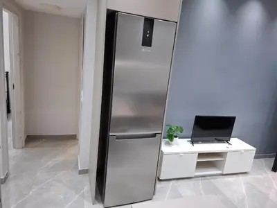 a stainless steel refrigerator next to a desk with a laptop at Nikaia Luxury Dream in Piraeus