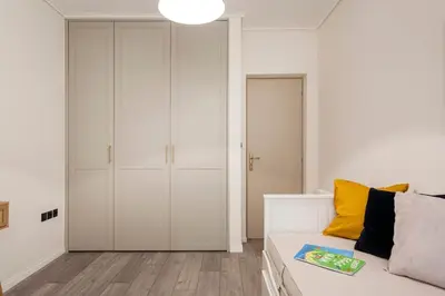 a living room with white cabinets and a couch at Luxury 3-BD condo with 80sqm balcony in Glifada in Athens