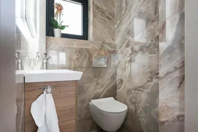 a bathroom with a sink and a toilet and a window at Luxury 3-BD condo with 80sqm balcony in Glifada in Athens