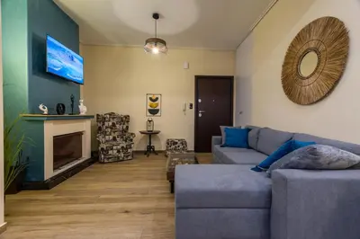 a living room with a couch and a fireplace at Kallithea fresh in Athens
