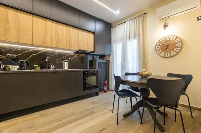 a kitchen with a table and chairs and a clock at Kallithea fresh in Athens