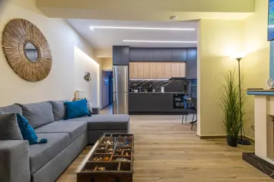 a living room with a couch and a kitchen at Kallithea fresh in Athens