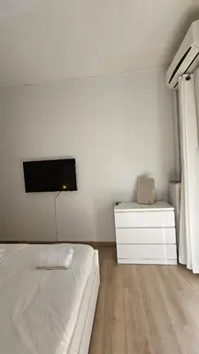 a bedroom with a bed and a tv on the wall at Lotus Suite Ampelokipoi in Athens