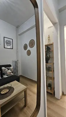 a mirror in a living room with a couch and a table at Lotus Suite Ampelokipoi in Athens