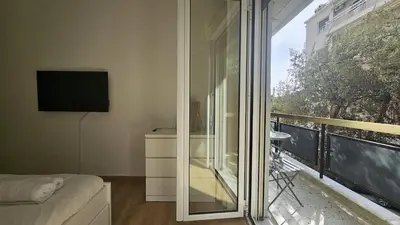 a bedroom with a balcony with a sliding glass door at Lotus Suite Ampelokipoi in Athens