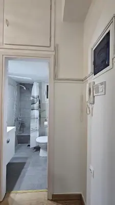 a white bathroom with a toilet and a sink at Lotus Suite Ampelokipoi in Athens