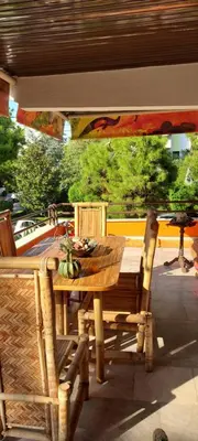 a wooden table and chairs on a patio at Beautiful apartment in the center of Glyfada in Athens