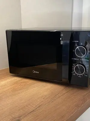 a black microwave sitting on top of a counter at Calma Athens in Athens