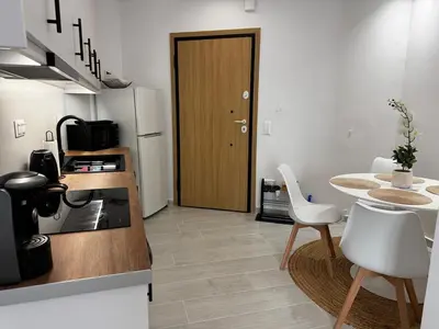a kitchen with a wooden door and a table and chairs at Calma Athens in Athens