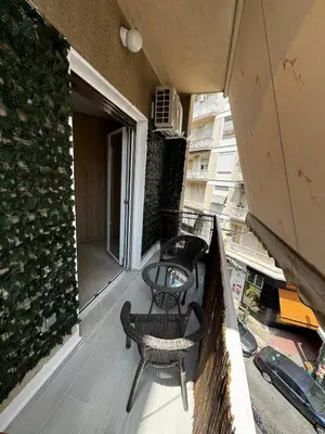 a balcony with chairs and tables on a building at Calma Athens in Athens