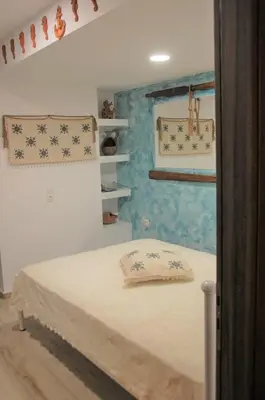 a bedroom with a bed and a blue wall at Aegean Pearl in Áyios Dhimítrios