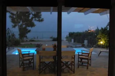 a table and chairs with a view of a pool at Aegean Pearl in Áyios Dhimítrios