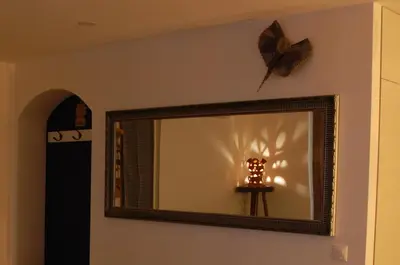 a mirror on a wall with a butterfly on the wall at Aegean Pearl in Áyios Dhimítrios