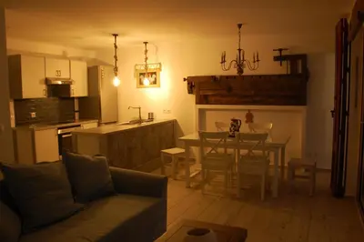 a living room and kitchen with a couch and a table at Aegean Pearl in Áyios Dhimítrios