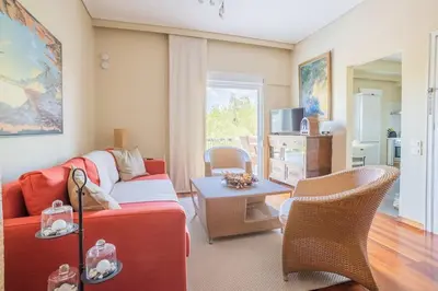 a living room with a red couch and a table at Dream-Stay apartment with a spacious balcony in Athens