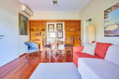 a living room with a red couch and a table at Dream-Stay apartment with a spacious balcony in Athens