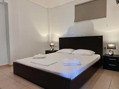 a bedroom with a bed with two towels on it at Seaview Complex with Pool in Porto Rafti
