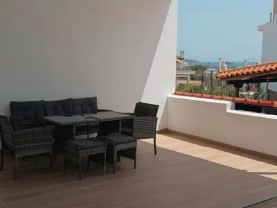 a black table and chairs on a balcony at Seaview Complex with Pool in Porto Rafti