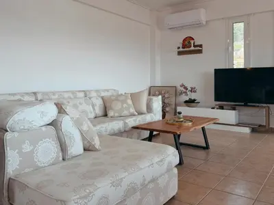 a living room with a couch and a tv at Seaview Complex with Pool in Porto Rafti