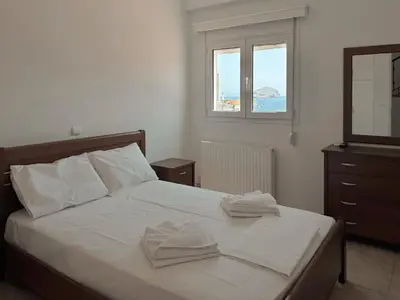 a bedroom with a bed with two towels on it at Seaview Complex with Pool in Porto Rafti