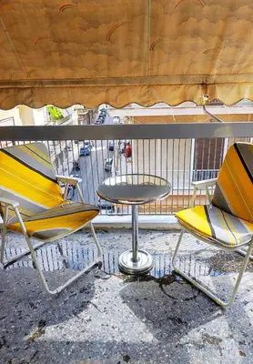 two chairs and a table in front of a fence at Imperial 2 in Athens