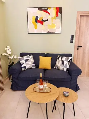 a living room with a blue couch and two tables at Panathenaic Stadium area Model Cozy Studio B in Athens
