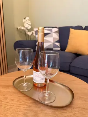 a bottle of wine and two wine glasses on a table at Panathenaic Stadium area Model Cozy Studio B in Athens