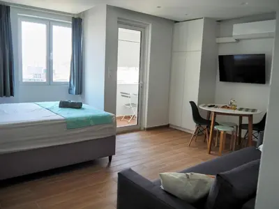 a bedroom with a bed and a table and a couch at Athens Pearl in Athens