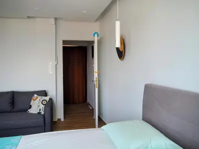 a bedroom with a bed and a couch and a door at Athens Pearl in Athens